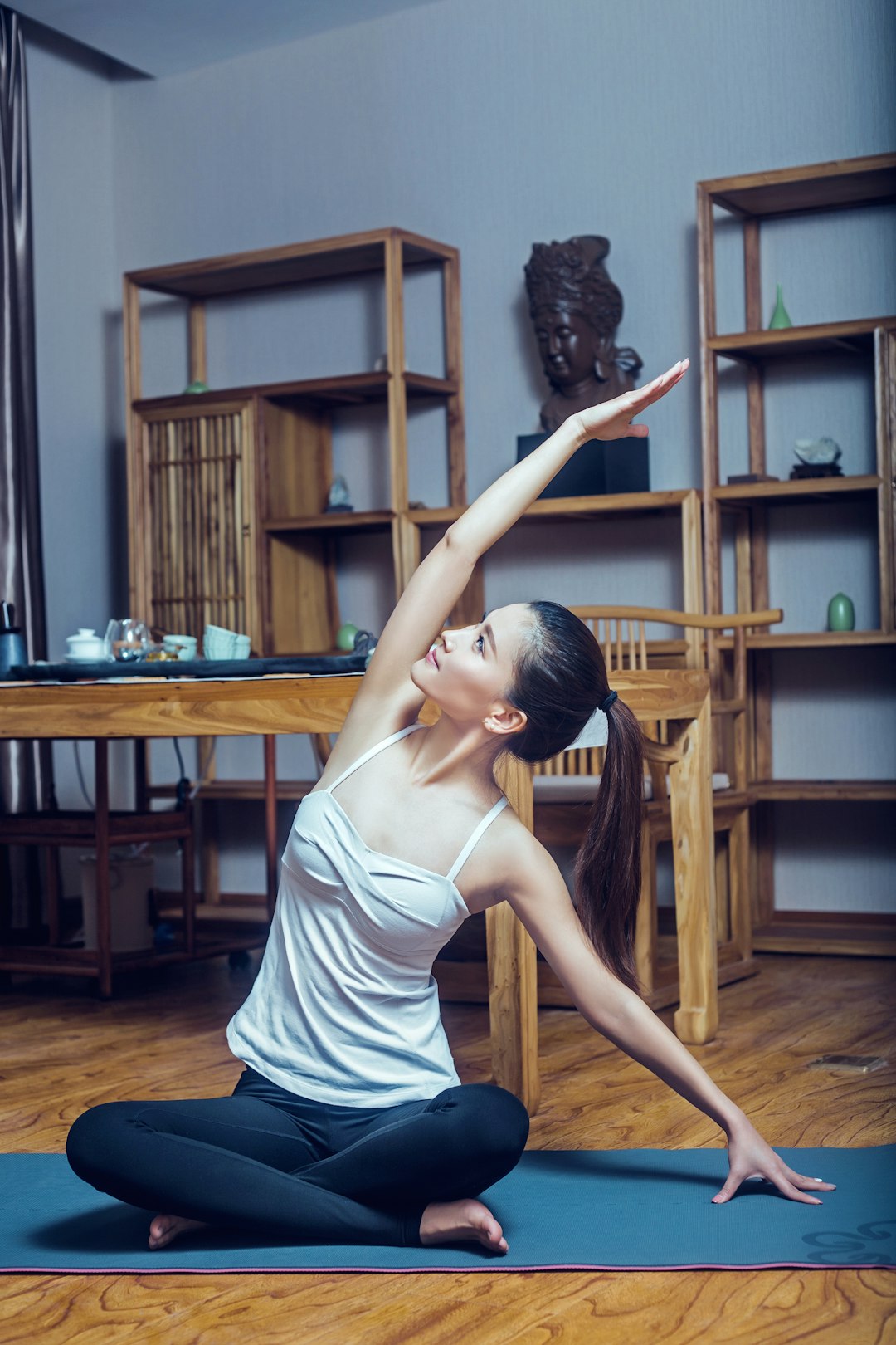 woman-in-white-tank-top-and-black-and-white-striped-skirt-sitting-on-brown-wooden-chair-c16gsjvy9p4